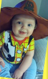 baby wearing a Toy Story Woody costume, smiling